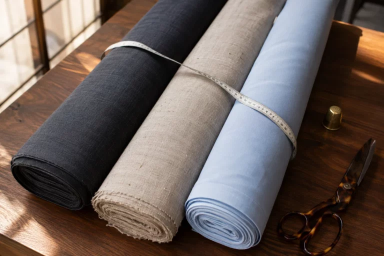 best suit fabrics for Bangkok's humid climate displayed on tailor's counter